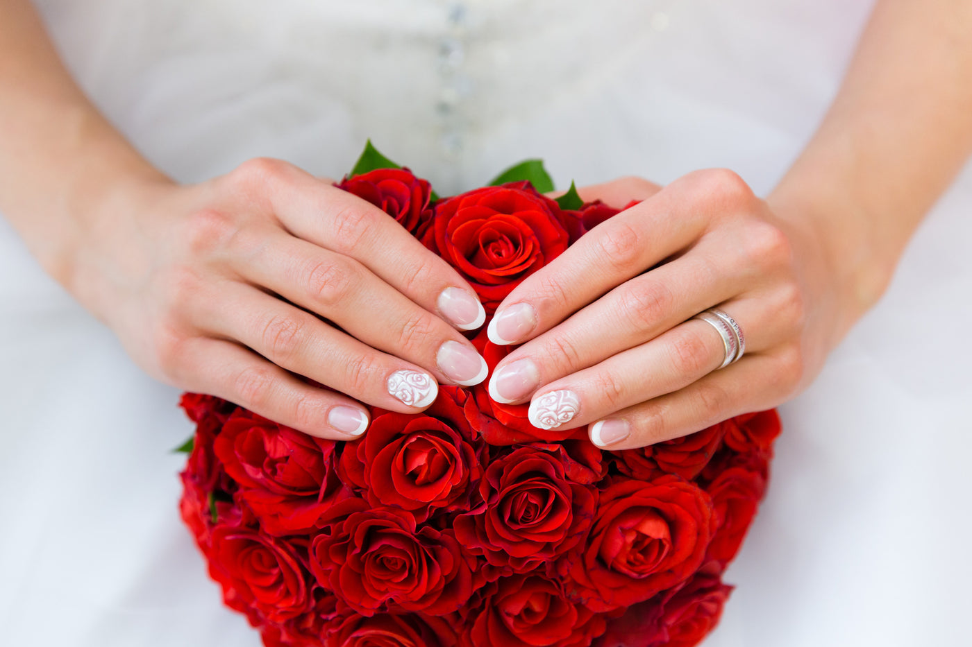 Bride with well manicured nails holding a bouquet 