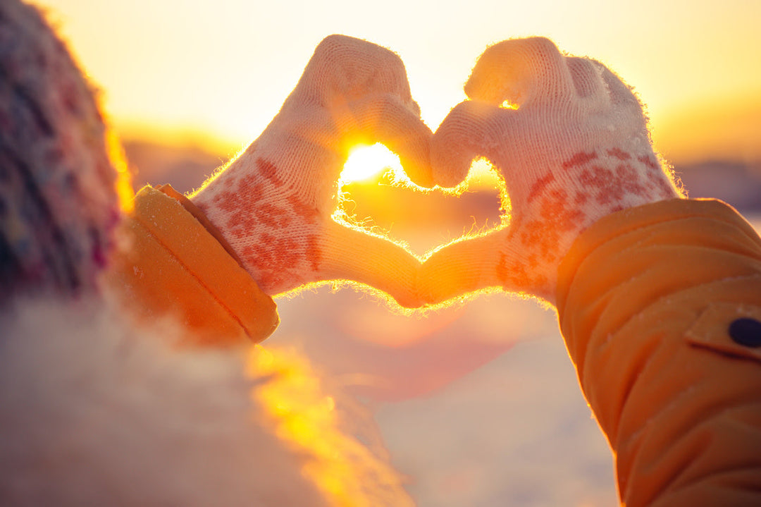 woman wearing gloves doing a love heart shape with her hands
