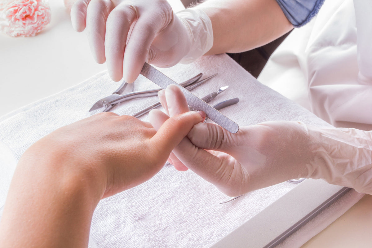 Profesional de uñas realizando una manicura