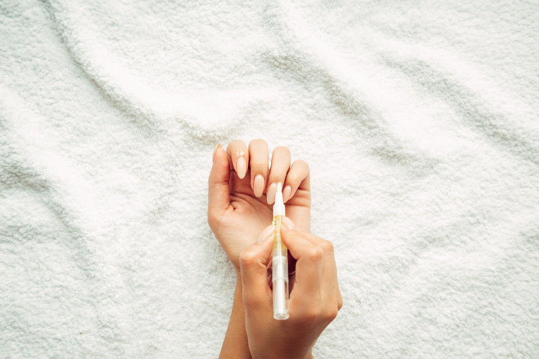 cuticle oil being used on nail