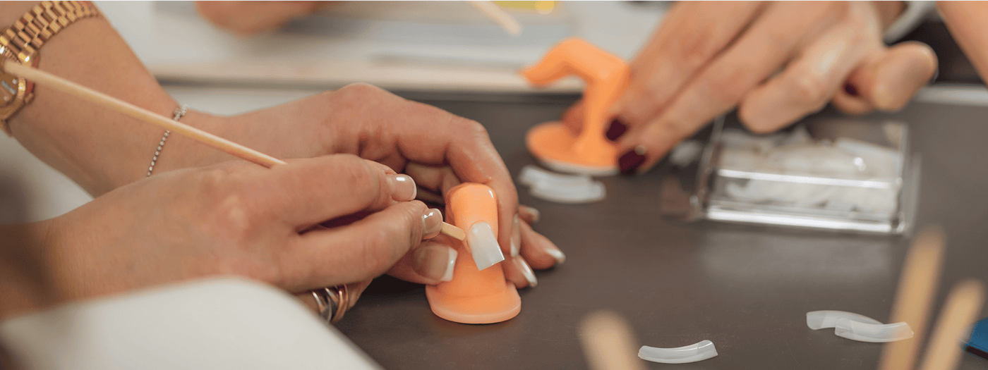 Nail technician training on a dummy finger