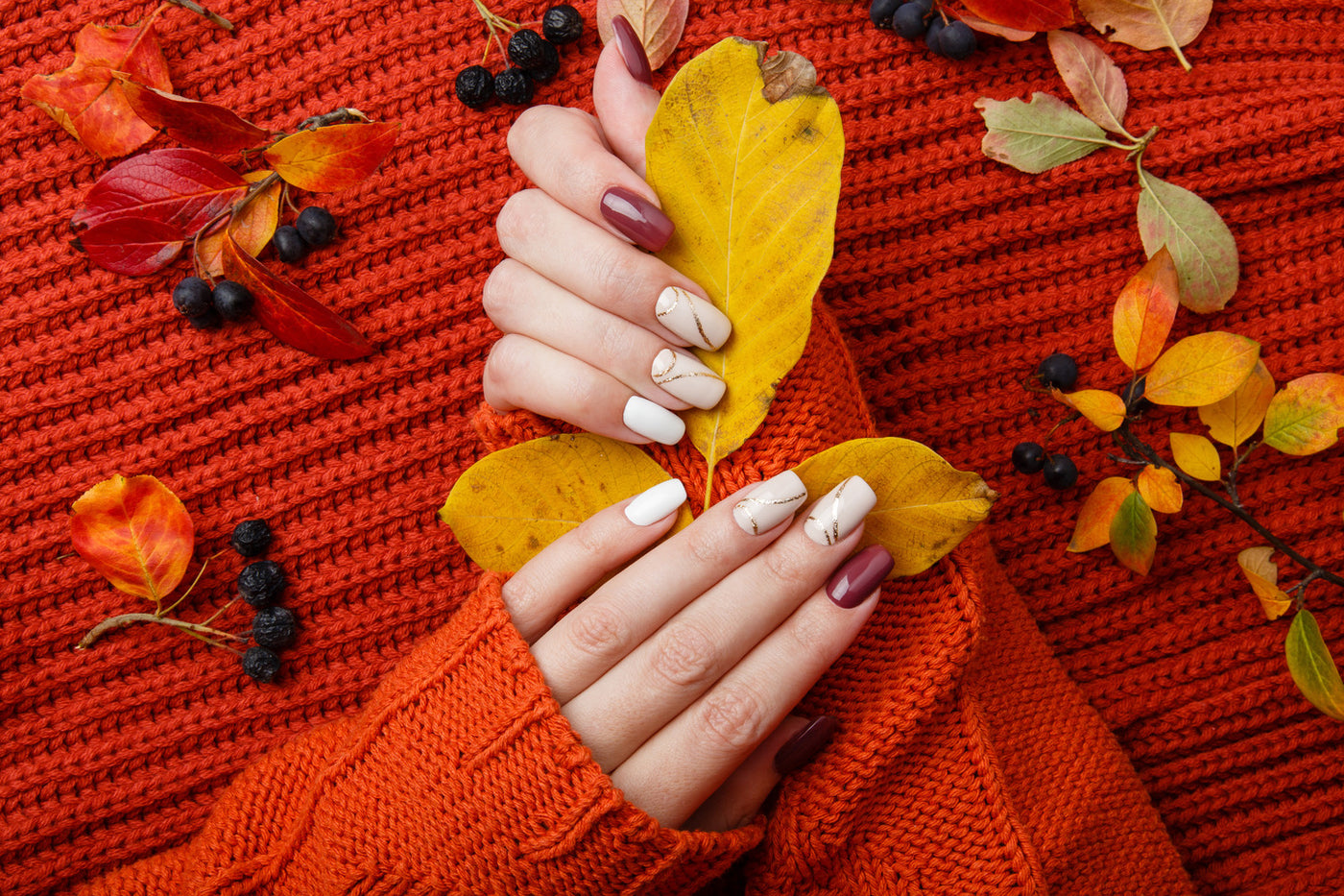 Autumnal nails holding a leaf