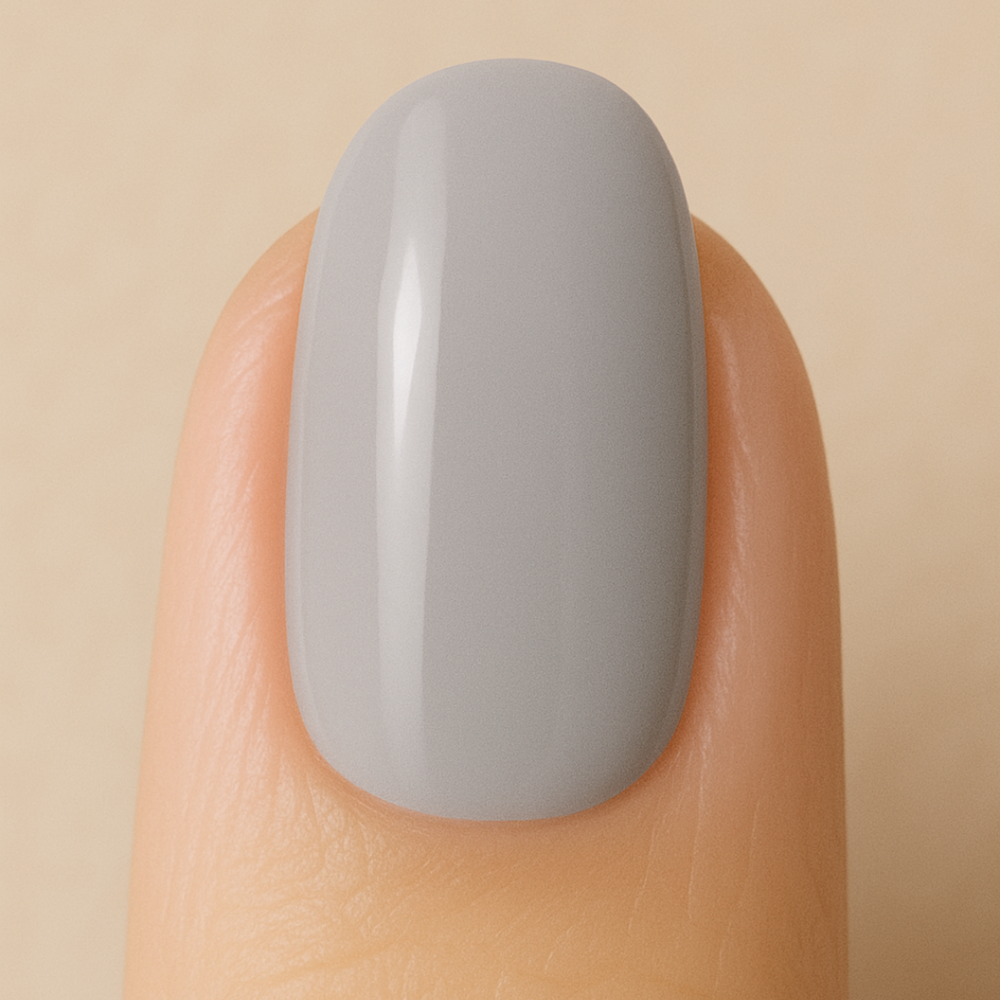 Nail with silver gel polish on a beige background